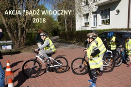 wychowankowie w kaskach i kamizelkach odblaskowych na rowerach